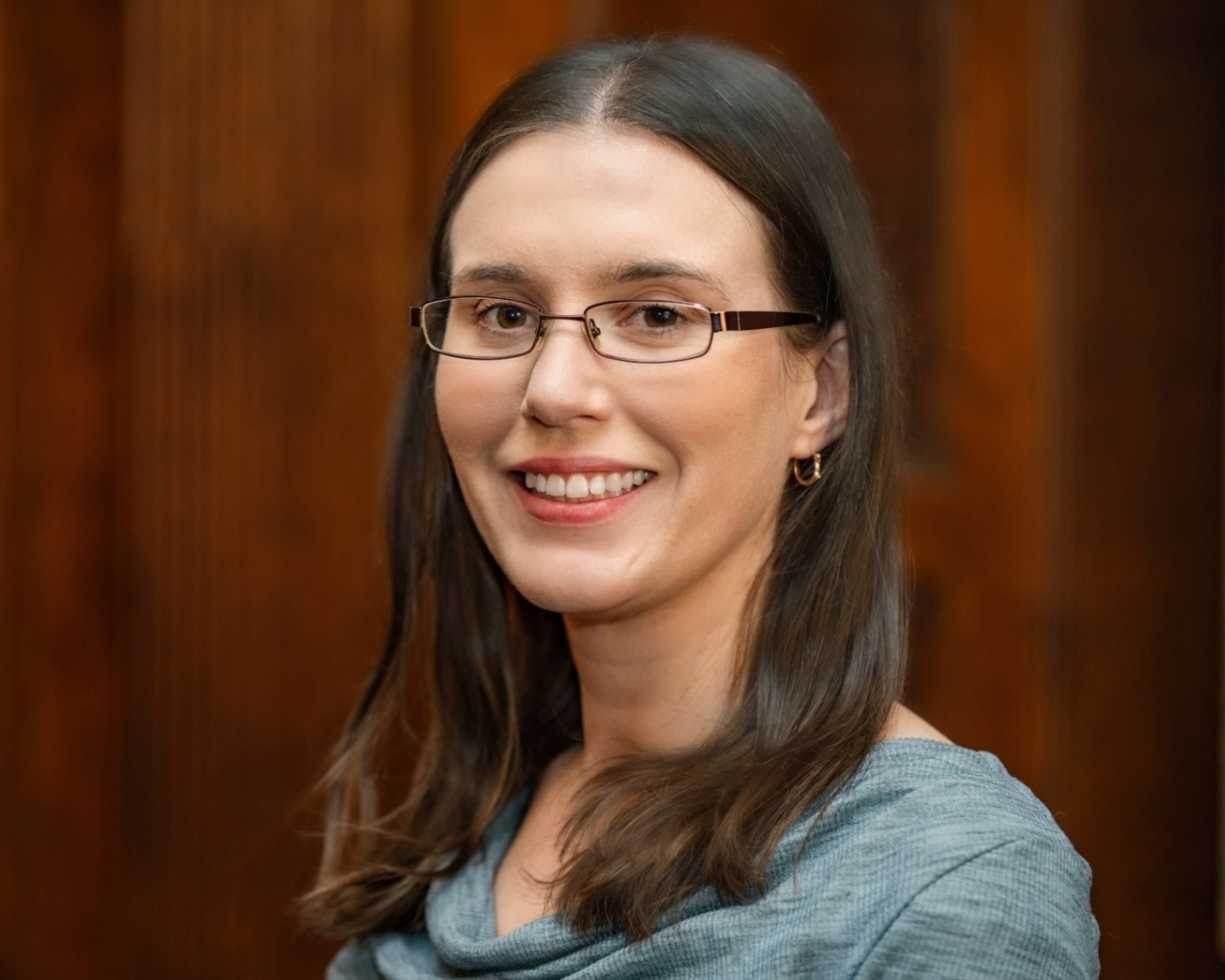 Portrait photo of a smiling woman wearing glasses